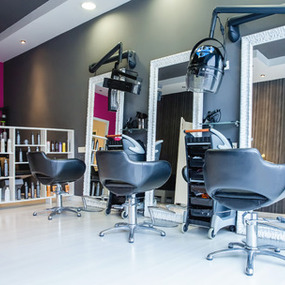 Moderner Friseursalon mit Frisierstühlen, Spiegeln und professioneller Haarausstattung.